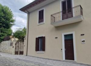 a white house with a balcony and a door at Villa Casinelli B&B in Isola del Liri