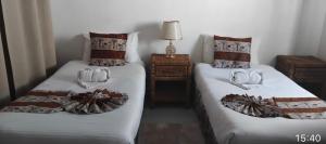 two beds in a room with towels on them at Queen Room self contained in Lusaka