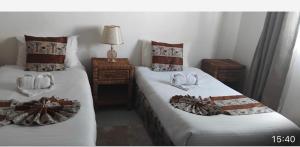 a bedroom with two beds with towels on them at Queen Room self contained in Lusaka +4 photos