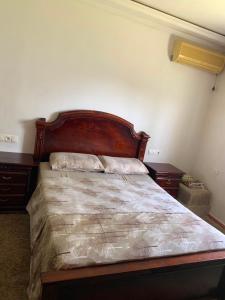 a bed with a wooden headboard in a bedroom at maison avec jardin in Cabo Negro