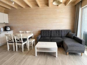a living room with a couch and a table at Silver Park Resort 10m do plaży in Gąski