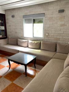 a living room with a couch and a coffee table at maison avec jardin in Cabo Negro +1 photo