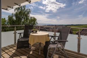 a patio with a table and two chairs on a balcony at Hotel Mohren in Hagnau