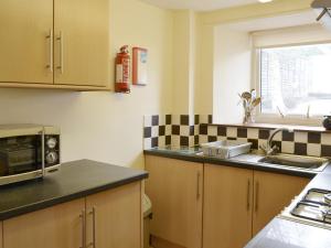 a kitchen with a sink and a microwave at St Abbs Cottage in Belford