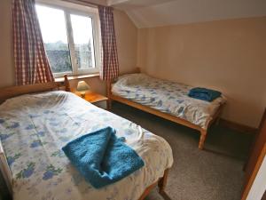 a bedroom with two beds and a window at St Abbs Cottage in Belford
