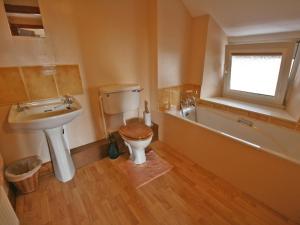 a bathroom with a toilet and a sink and a window at St Abbs Cottage in Belford