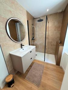 a bathroom with a sink and a shower with a mirror at Le Salon des Voyageurs - Appartement Climatisé avec Terrasse et Parking Gratuit à Proximité in Dole +25 photos