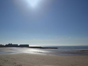 a sandy beach with the ocean in the background at Cheviot Cottage in Belford