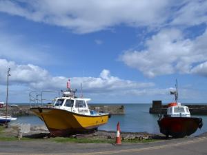 two boats parked on the shore of the water at Cheviot Cottage in Belford +1 photo