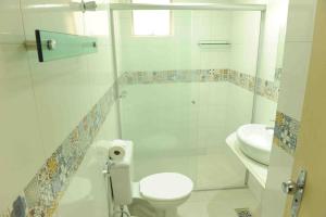 a bathroom with a toilet and a sink at Oft Garden hotel in Goiânia