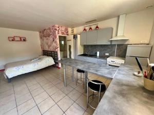a kitchen with a table and a bed in a room at Chez Christelle in Audenge