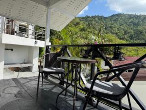 eine Terrasse mit zwei Stühlen und einem Tisch auf einem Balkon in der Unterkunft BRW Samui in Bophut  + 14 Fotos