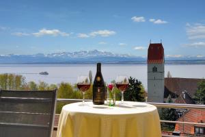 a table with two glasses and a bottle of wine at Hotel Mohren in Hagnau