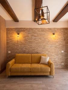 a couch in a room with a brick wall at Yes I Know My Room - La Rua in Castel di Sangro +1 photo