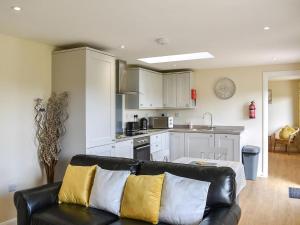 a living room with a couch and a kitchen at Sherwood Forest Lodge 2 in Clipstone