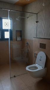 a bathroom with a toilet and a shower in it at Lofted Peaks in Pālampur +16 photos