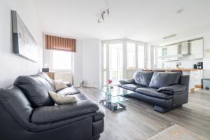 a living room with two couches and a glass table at Komfortable Ferienwohnung für 2 am Südstrand mit Wintergarten & Meerblick Wohnung 12 in Wilhelmshaven
