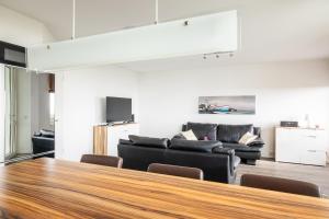 a living room with a couch and a table at Komfortable Ferienwohnung für 2 am Südstrand mit Wintergarten & Meerblick Wohnung 12 in Wilhelmshaven +9 photos