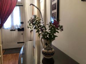 a vase with flowers sitting on a glass table at Rectory Cottage in Croydon
