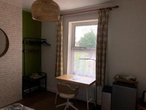 a room with a desk in front of a window at Rectory Cottage in Croydon