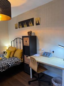 a desk in a room with a bed and a desk with a chair at Rectory Cottage in Croydon