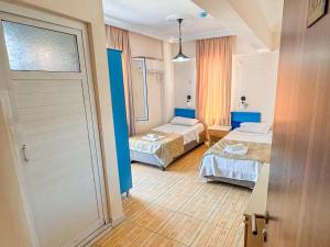 a hotel room with two beds and a door at Er-öz Hotel & Restaurant in Fethiye