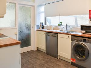 a kitchen with a washer and dryer in it at Gwynfa in Rhyl