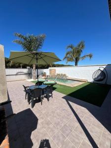a patio with a table and chairs and an umbrella at Casa Martina in Cádiz +3 photos