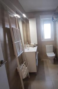 a bathroom with a sink and a toilet and a window at Casa Martina in Cádiz