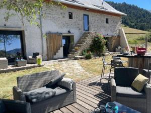 a patio with chairs and a table and a house at Forest d' ARTO in Ancelle