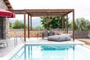 a swimming pool with a table and chairs next to a house at Τilevoides Nisi Villas in Spartokhórion
