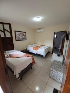 a hotel room with two beds and a window at Pousada Mirantes Do Sincorá in Mucugê