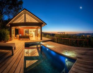 a house with a swimming pool at night at Bush Lodge at Hidden Valley Wines in Stellenbosch