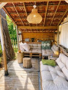 a covered patio with white couches and a chandelier at Little Bali in Geel