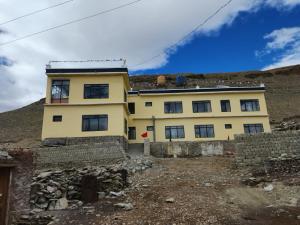 a yellow house on top of a hill at Zim Retreat Tsokar in Pongunagu