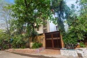 a building with a gate and trees in front of it at MG Villa - A Boutique Stay in Navi Mumbai