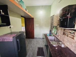 a kitchen with a black refrigerator and a counter at Sunrise Strength Club in Villupuram