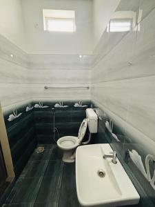 a bathroom with a toilet and a sink at Sunrise Strength Club in Villupuram +6 photos