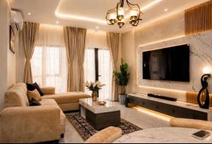 a living room with a couch and a tv at Massa Residence Meublé Yaounde in Yaoundé