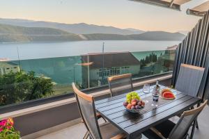 a wooden table with a bowl of fruit on a balcony at Casa sul Mare Luxury Sea View Apartments in Neum