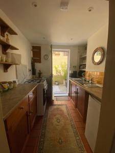 a kitchen with wooden cabinets and a tile floor at Glen Villa - 3 bedroom house - Stroud town centre in Stroud