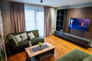 a living room with a green couch and a tv at Casa sul Mare Luxury Sea View Apartments in Neum