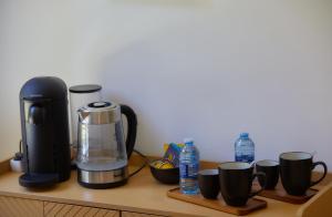 a coffee maker and coffee cups on a counter at Manoir de L'Echauguette in Laignes