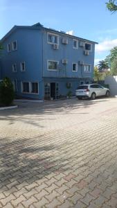 a blue building with a car parked in front of it at Vila Ali Demi in Tirana