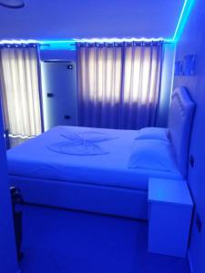 a bedroom with a bed with a blue light at Vila Ali Demi in Tirana +11 photos