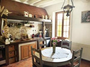 a kitchen with a table and a table and chairs at La savignacoise in Savigny-en-Sancerre