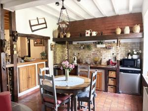 a kitchen with a table and chairs in a room at La savignacoise in Savigny-en-Sancerre