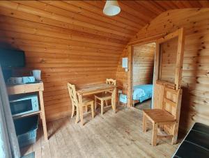 a room with a table and chairs in a log cabin at Broomfields Glamping Pods in Whitby