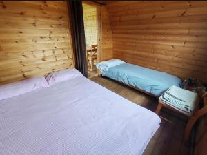 a bedroom with two beds in a log cabin at Broomfields Glamping Pods in Whitby