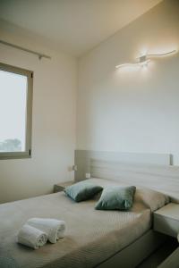 a bedroom with a bed with two pillows and a window at Nonno Turiddru Guest House in Marsala